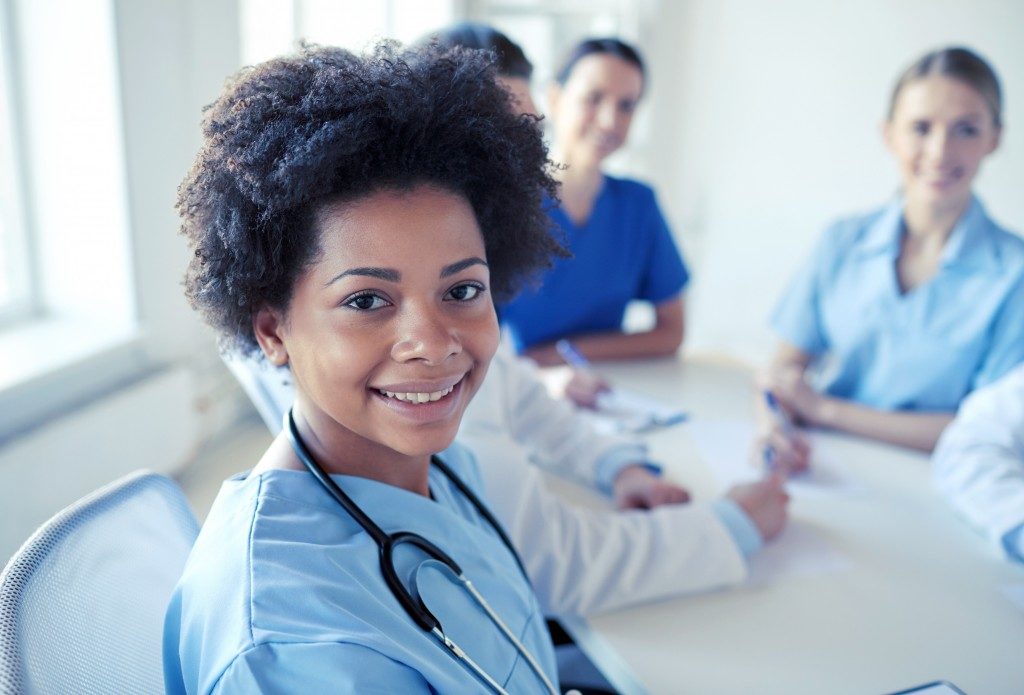 Health care people together with woman smiling to the camera