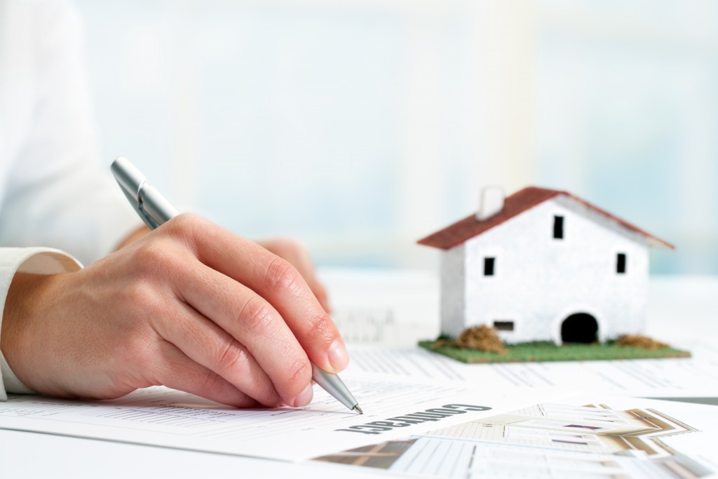 a woman filling up a document for a real estate asset
