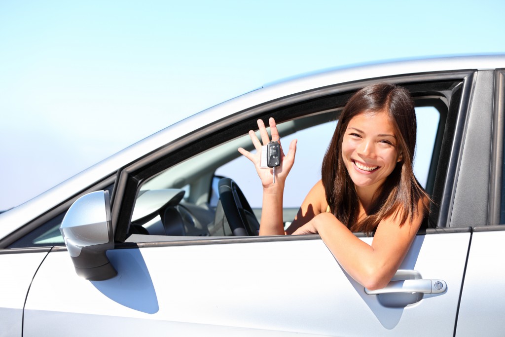 Woman inside car while holding car keys