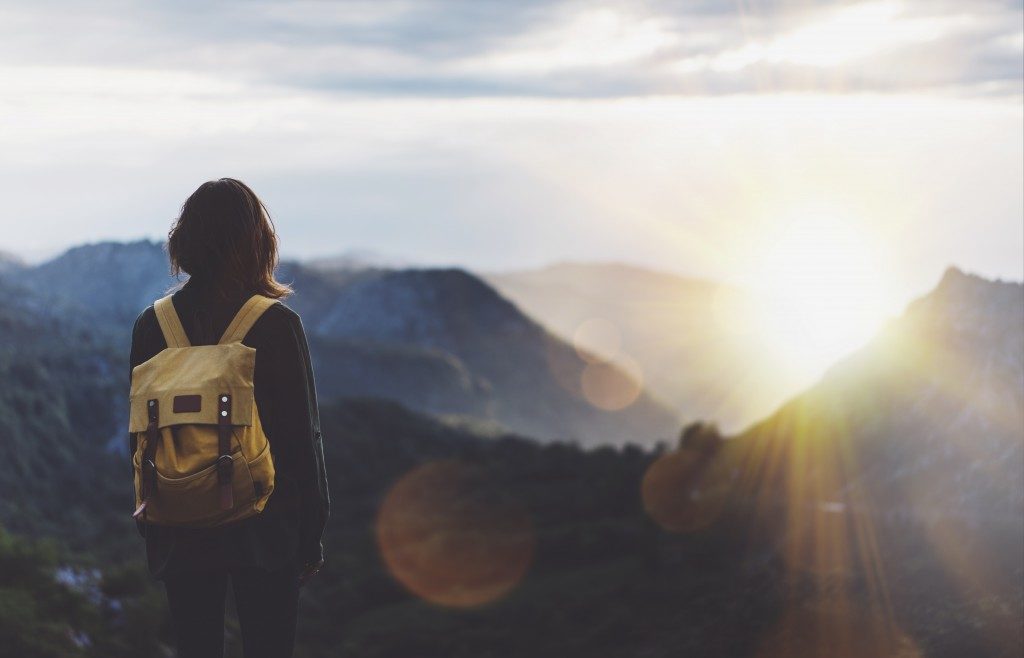 girl with backpack enjoying sunset
