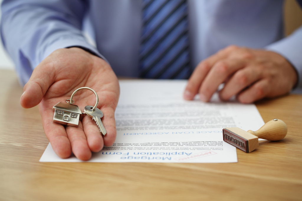 A man presenting a key with a house keychain