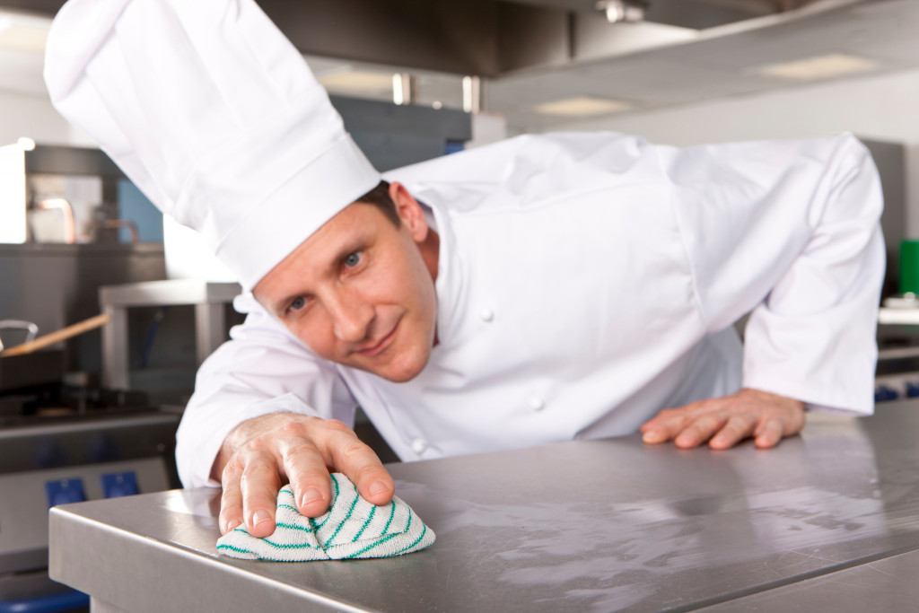 A chef cleaning a counter in a kitchen
