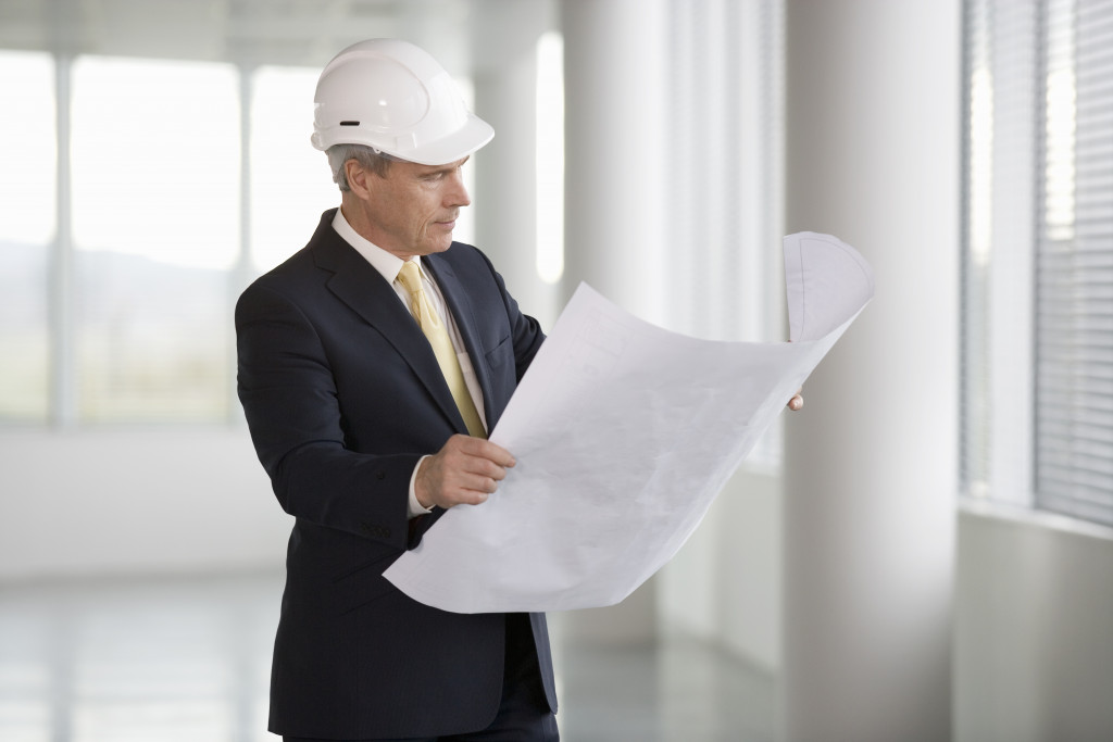 professional man holding a plan for a construction project